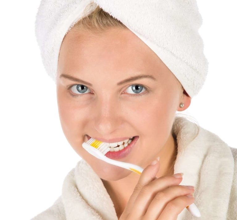Giovane donna fa la corretta igiene orale lavandosi i denti