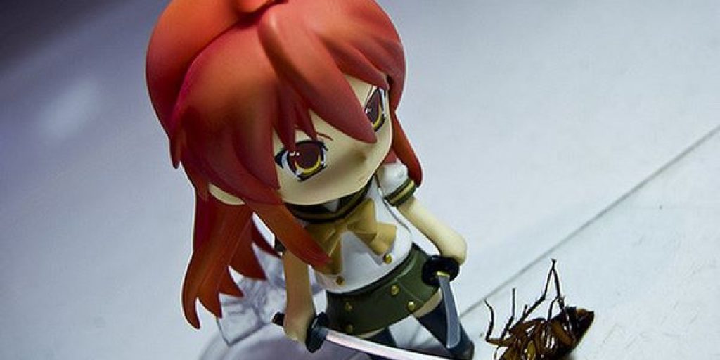 Bambolina con spada in mano e scarafaggio morto