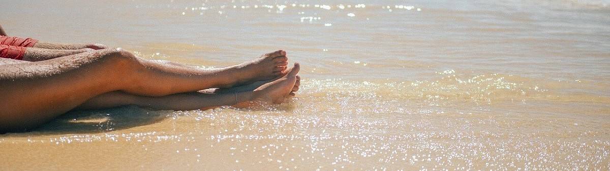 Gambe in perfetta forma sul bagnasciuga Gambe scoperte ben curate in estate sulla spiaggia