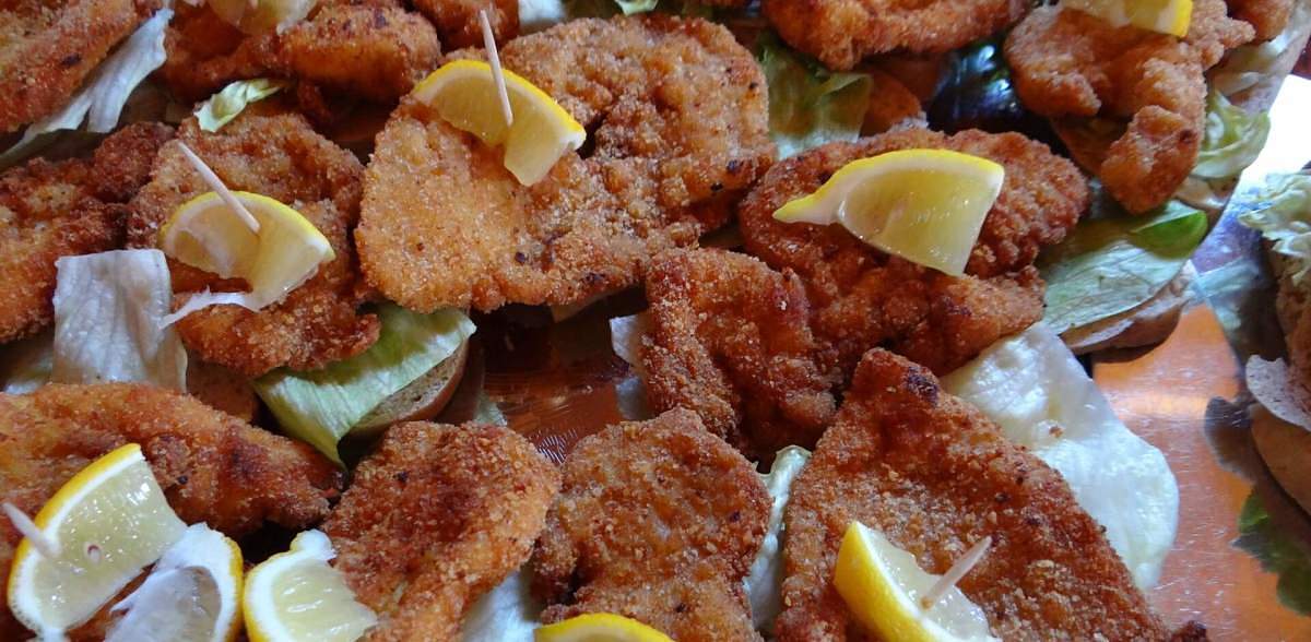 Cotolette fritte fredde con verdure e spicchi di limone