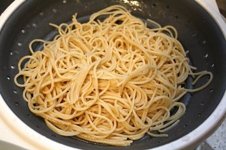 Spaghetti cotti fatti scolare nel colapasta