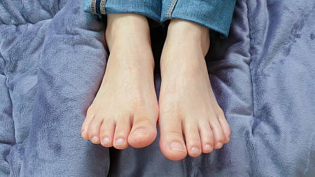 Piedi femminili con unghie senza smalto applicato