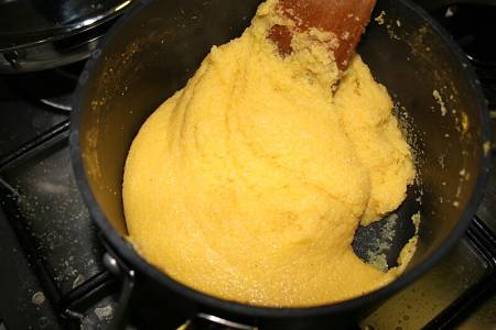 Cpme girare la polenta con cucchiaio di legno lungo