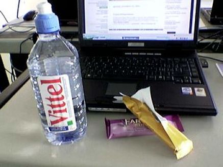 Bottiglietta di acqua accanto al computer portatile