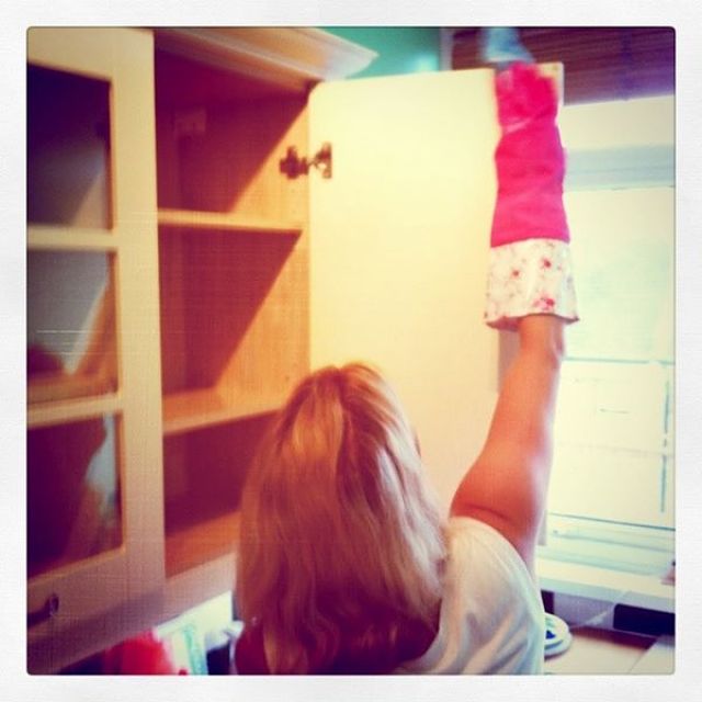 Donna pulisce l'interno del pensile di cucina