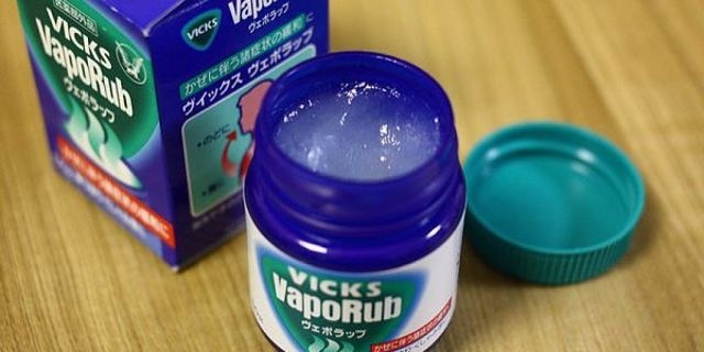Unguento curativo Vicks Vaporub nella sua tipica confezione in vetro blu con scatola accanto