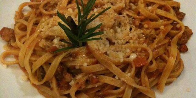 Tagliatelle al ragù di faraona con generosa spoverata di parmigiano grattugiato
