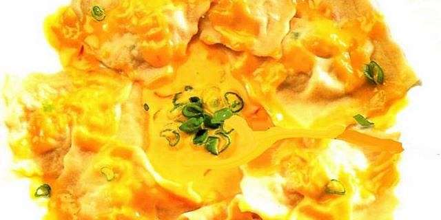 Ravioli al ripieno di granchio con salsa allo zafferano Immagine di ravioli di polpa di granchio con salsa allo zafferano