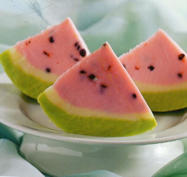 Fresco dessert di gelato ai colori dell'anguria Anguria finta di gelato di pistacchi, crema, fragola e gocce di cioccolato