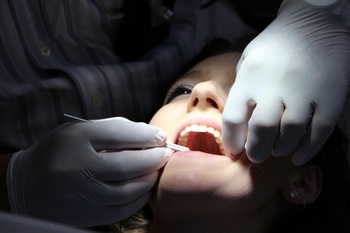 Dentista controlla la bocca della paziente