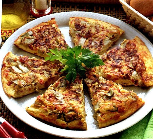 Tortilla con carciofi e ricotta Tortilla spagnola ricca presentata in tavola già tagliata