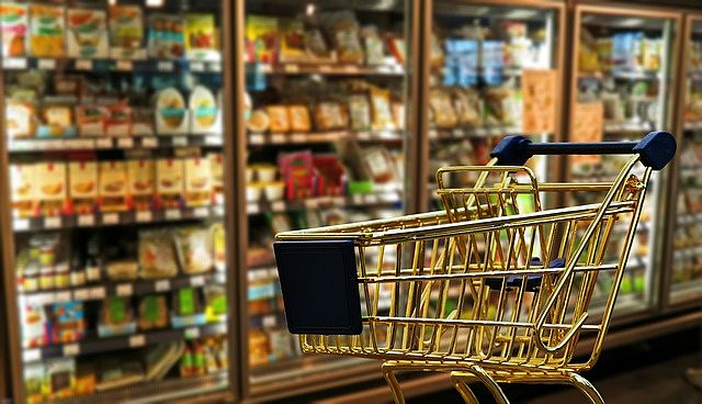 Carrello davanti al frigorifero dei supermercato con prodotti di Private Label nei ripiani bassi