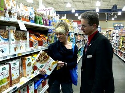 Clienti leggono i valori nutrizionali sull'etichetta di un prodotto alimentare