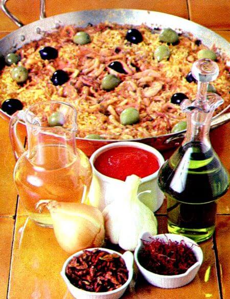 Calamaretti con riso alla spagnola Calamaretti con riso e zafferano nella pentola di cottura