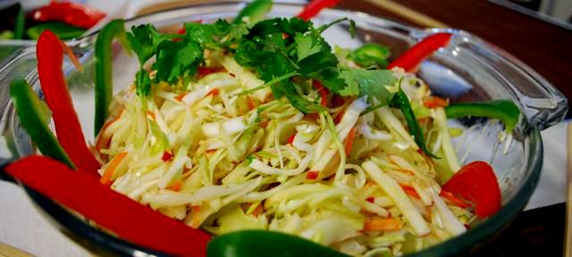 Insalata di cavolo cappuccio e verdure Insalata cruda di cavolo, porri e carote in agrodolce decorata con falde di peperoni