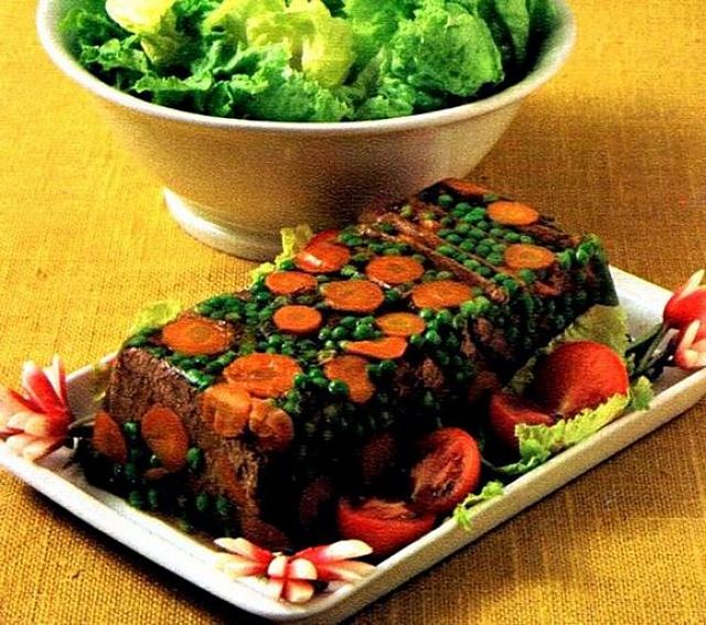 Raffinato aspic di carne e verdure in gelatina L'aspic di manzo, carote e piselli in gelatina fa figura ed è bello a vedersi