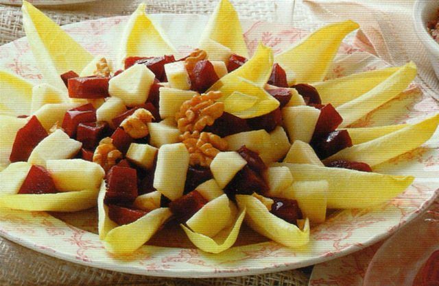Piatto con insalata di indivia, mele, barbabietole e noci da condire con panna acida