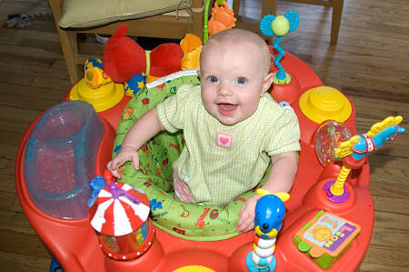 Bebè di 5 mesi gioca nella sdraietta con balocchi adatti alla sua età