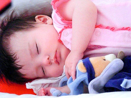 Neonata dorme con il suo animale di peluche doudou