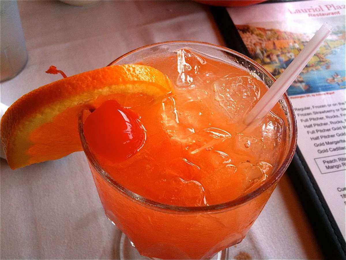 Cocktail tequila sunrise decorato con ciliegia allo sciroppo e fettina di arancia