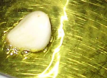 Spicchio di aglio spellato nell'olio in padella