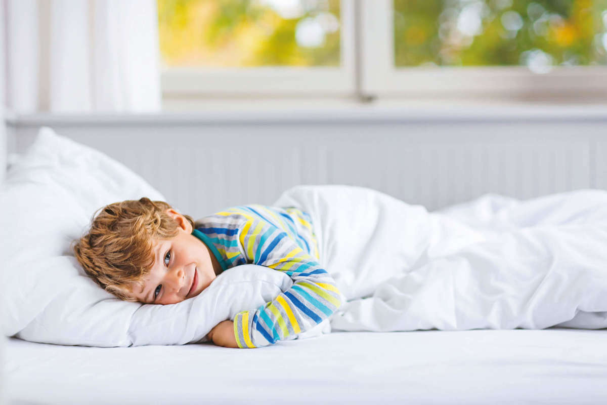 Bambino sano e sorridente a letto