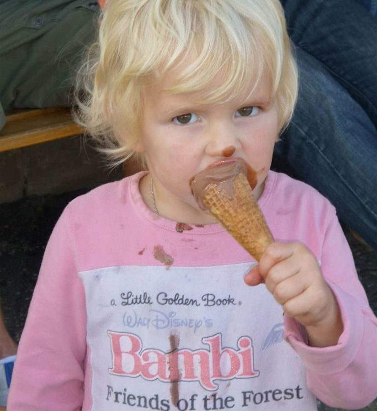 Bambina macchia la maglietta di cioccolato mangiando il gelato