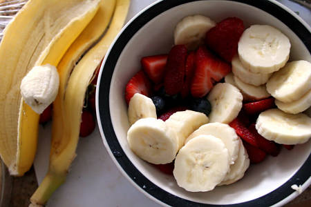 Fragole e banane tagliate nella ciotola