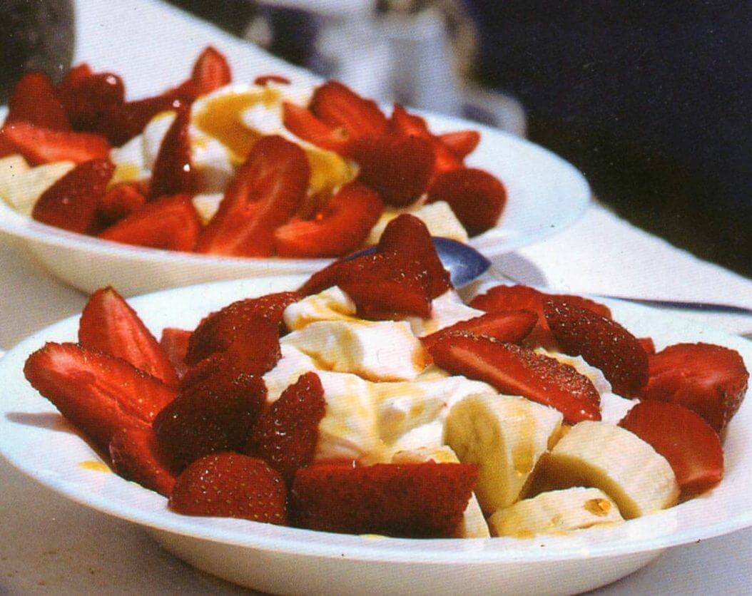 Ciotole con mix di yogurt, fragole, banane e miele