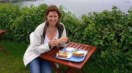 Donna fa un pranzo leggero con sandwich all'aria aperta