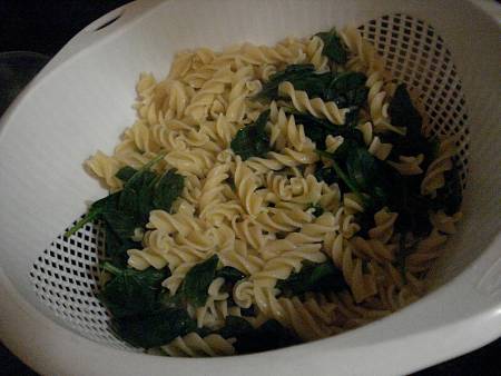 Pasta e spinaci lessati nello scolapasta