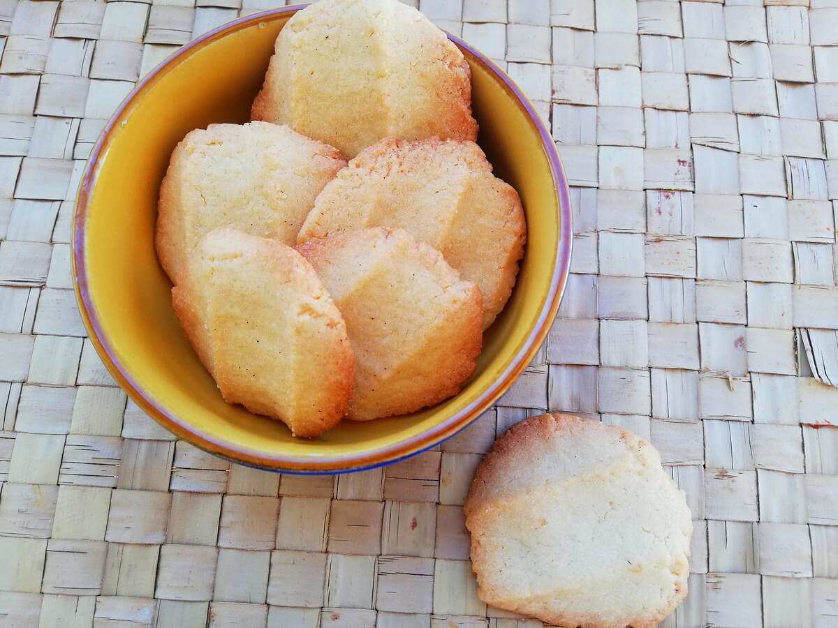 I biscotti di frolla al limone sono genuini e fragranti Ciotola con bBiscotti di pasta frolla al limone fatti in casa