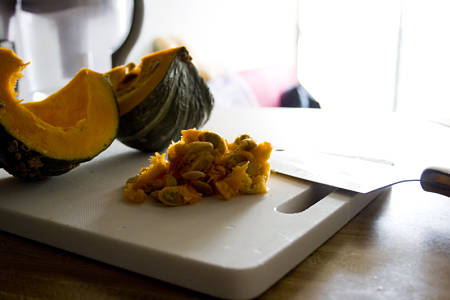 Zucca aperta con semi, polpa molle e filamenti sul tagliere