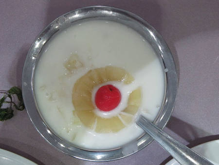 Raita di ananas decorata con fetta del frutto e ciliegia sciroppata