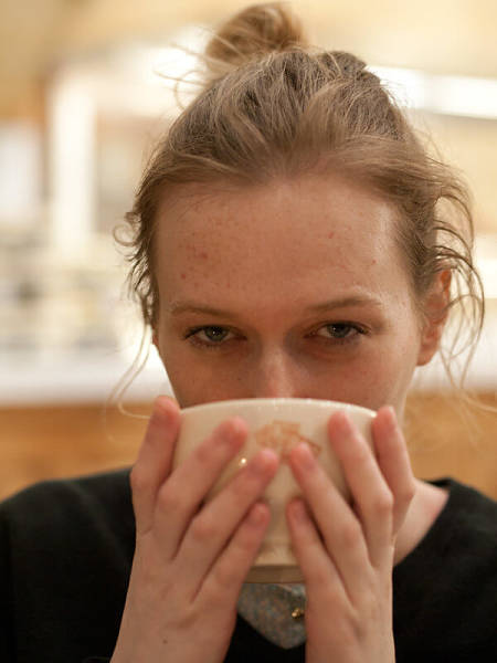 Giovane donnabeve tisana a piccoli sorsi