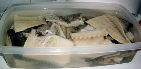 Baccalà tagliato a pezzi messo ad ammollare nell'acqua