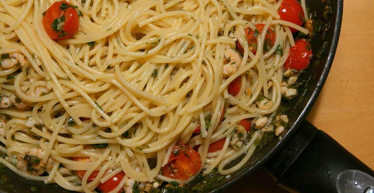 Spaghetti cotti in padella assieme a pomodorini e gamberetti