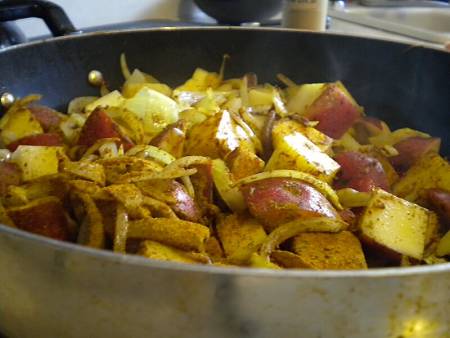 Cipolle, patate e polvere di curry in casseruola