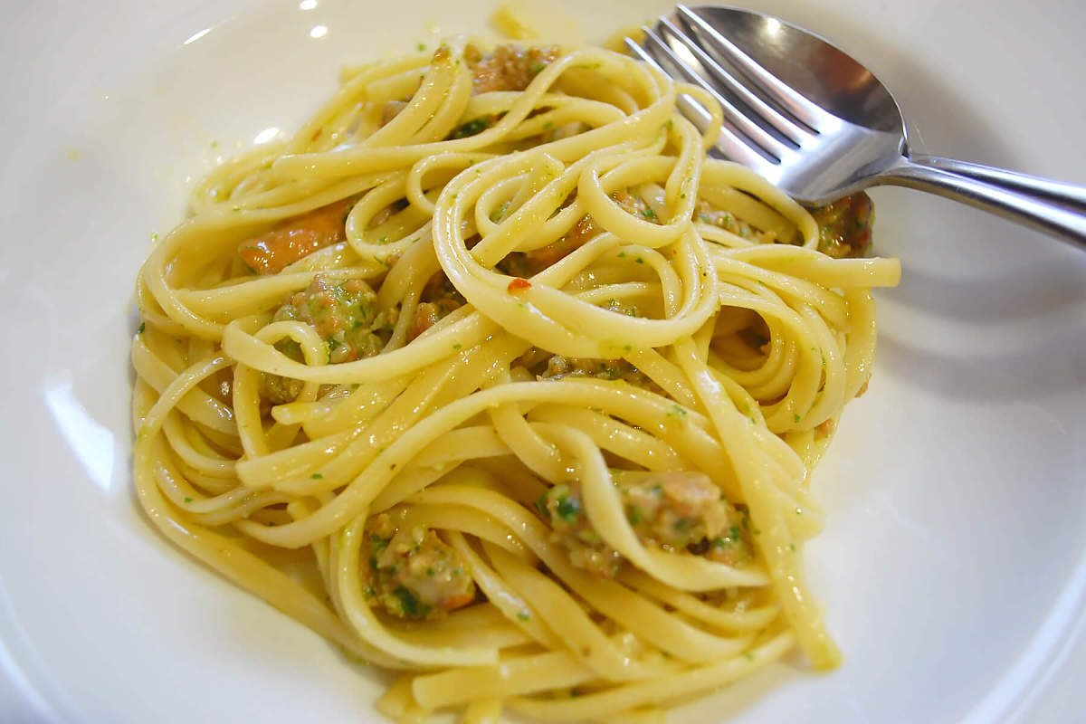 Le linguine con salsiccia e pesto di prezzemolo e scaogno sono un piatto calabrese senza pomodoro Linguine condite con salsiccia e pesto di scalogno e prezzemolo in bianco
