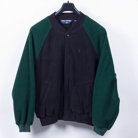 Felpa in pile verde e blu appesa alla gruccia