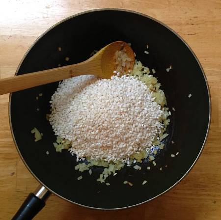 Riso crudo aggiunto al soffritto di cipolla