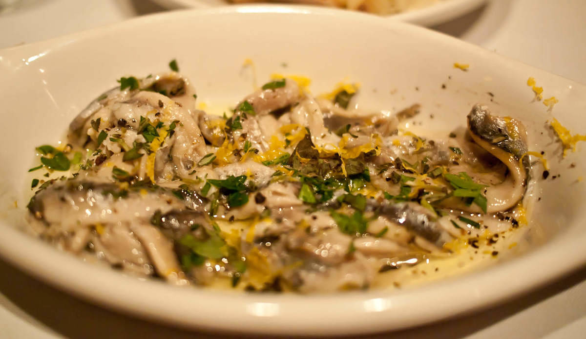 Acciughe scottate condite con buccia di limone e prezzemolo Acciughe scottate con scorza di limone grattugiata e prezzemolo tritato