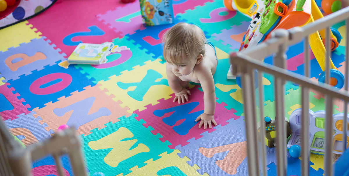 Bambino gattona su tappeto gioco pulito