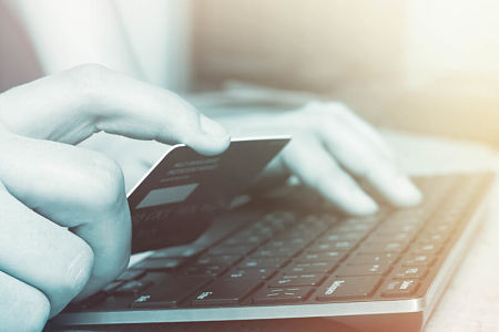 Donna fa shopping online con la carta prepagata