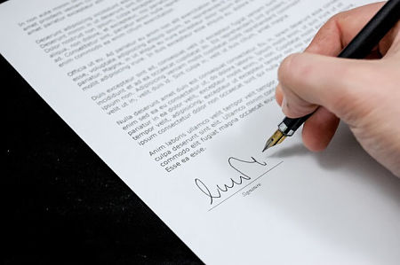 Uomo firma un contratto dopo averlo letto