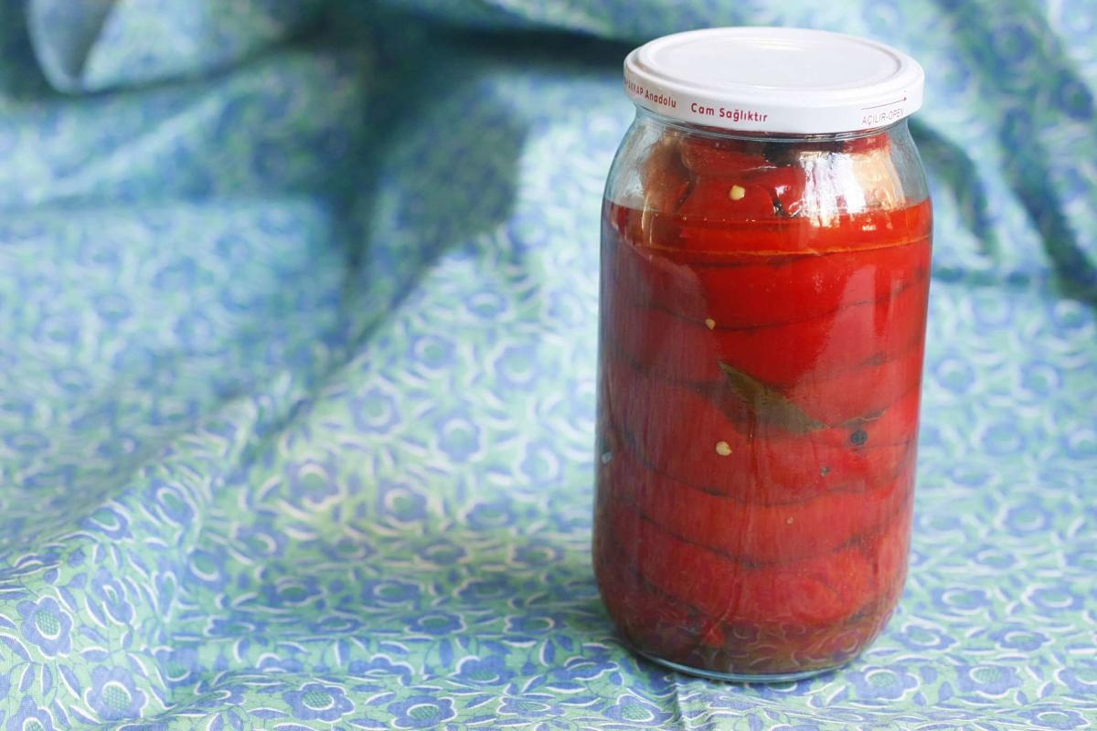 Vaso di vetro contenente genuini peperoni in salamoia Peperoni insalamoia dentro a vaso di vetro chiuso