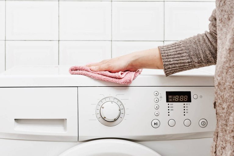 Donna effettua la pulizia della lavatrice