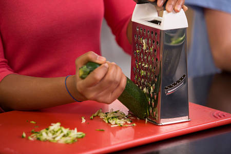 Donna grattugia una zucchina