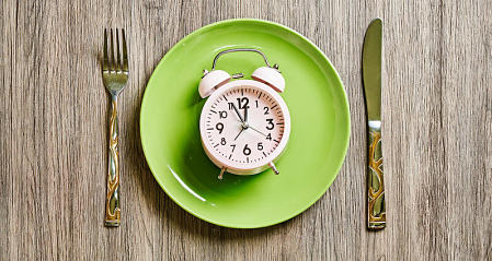 Orologio segna le 12 su coperto apparecchiato