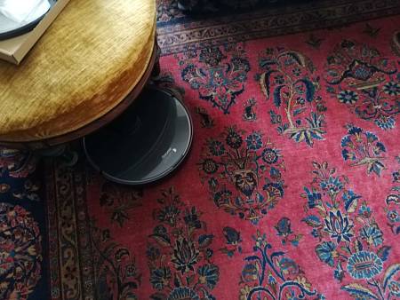 Dreame L10 PRO mentre aspira la polvere dal tappeto e sotto una poltrona